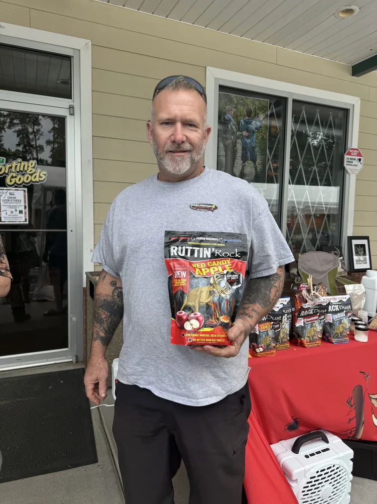 Shopper holding Ruttin' Rock deer attractant at Irby Street Sporting Goods, Florence SC